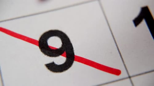 The 9St Number in the Calendar is Crossed Out with a Red Cross in a Macro on a White Sheet
