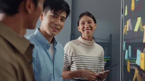 Asia businesspeople stand behind transparent glass wall listen manager pointing progress work.