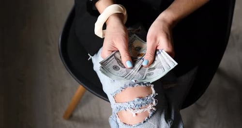 Closeup of an anonymous woman hold in hands and counting new one hundred dollar bill banknotes