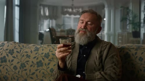 Old Business Man Sitting Sofa with Whiskey Glass