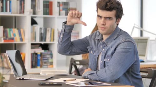 Thumbs Down By Creative Man Looking at Camera