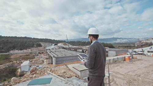 Man flying a drone for construction survey in a large highway construction site
